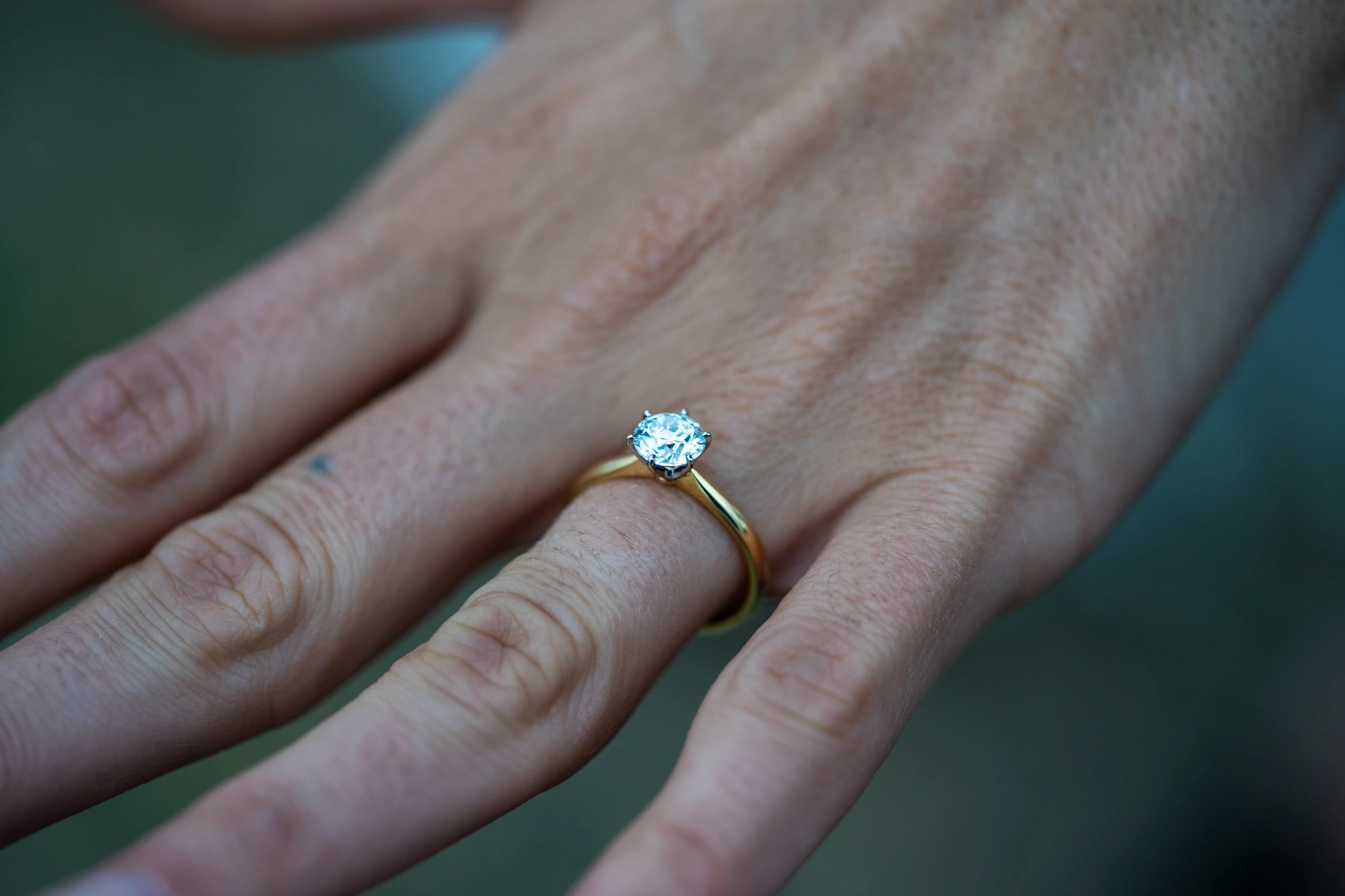 Close view of a diamond engagement ring on a woman's hand.
