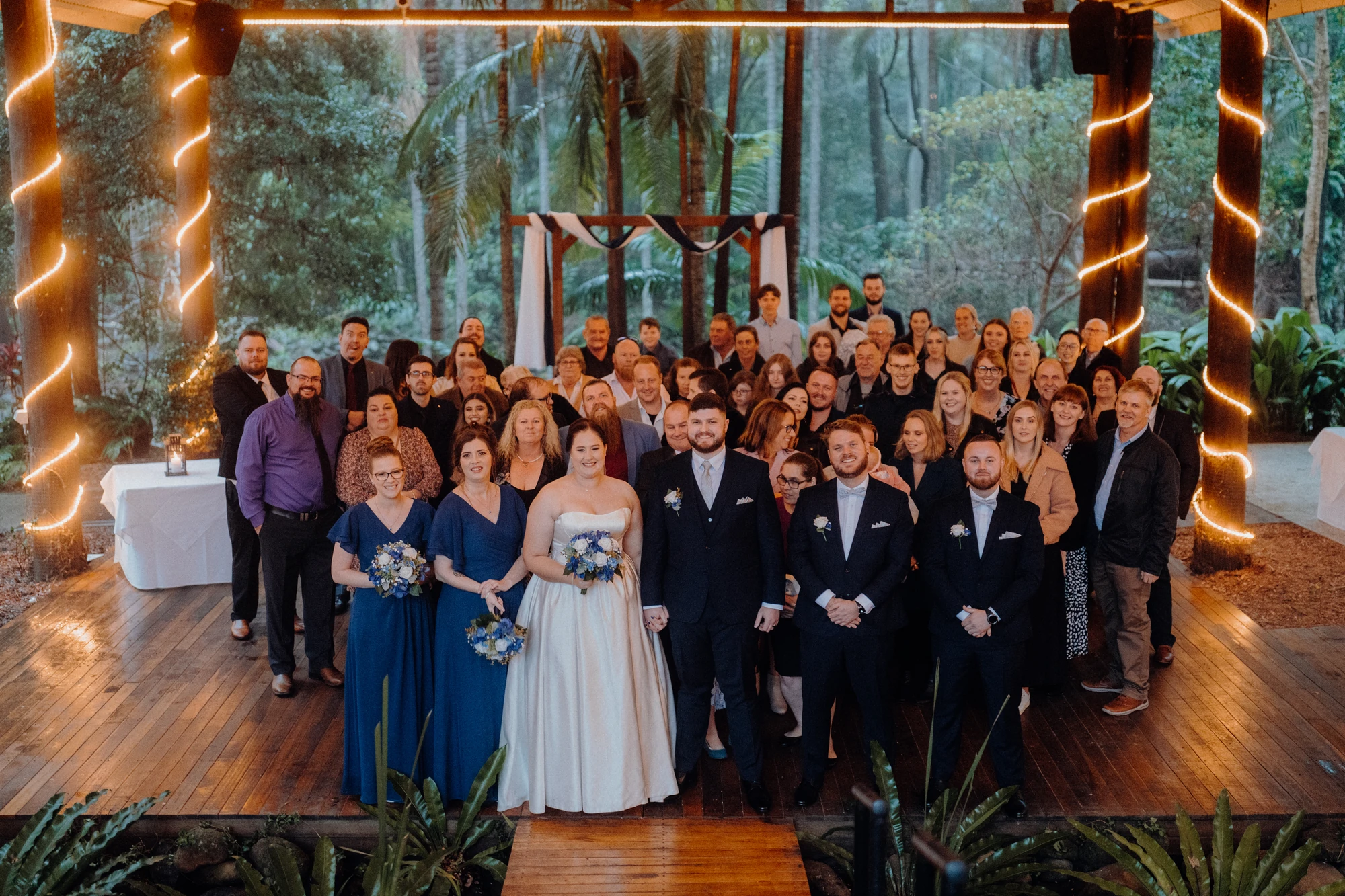 Wedding guests gather with the couple for a group photograph inside the chapel.