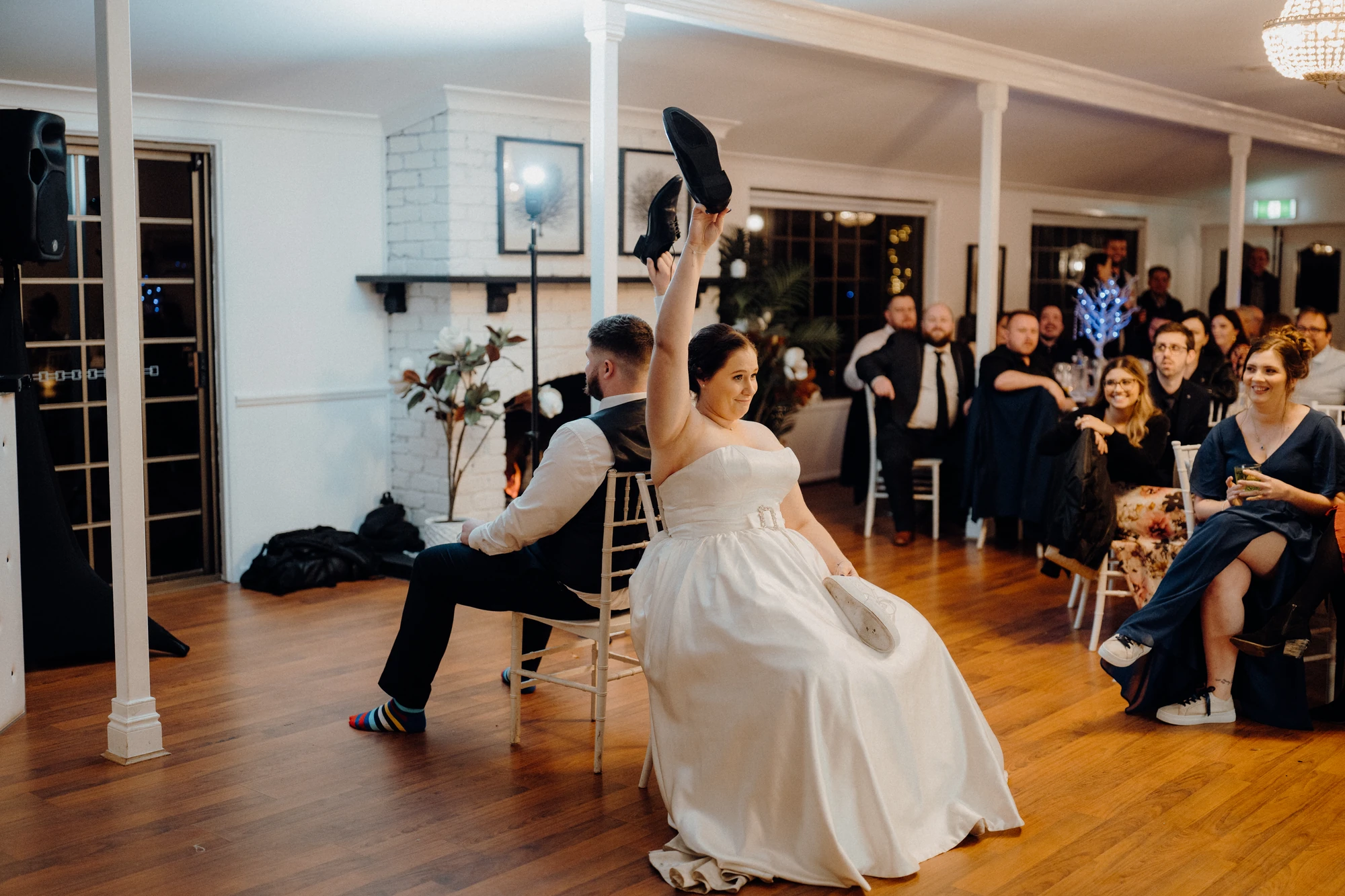 A bride raises a shoe during a game at the reception.