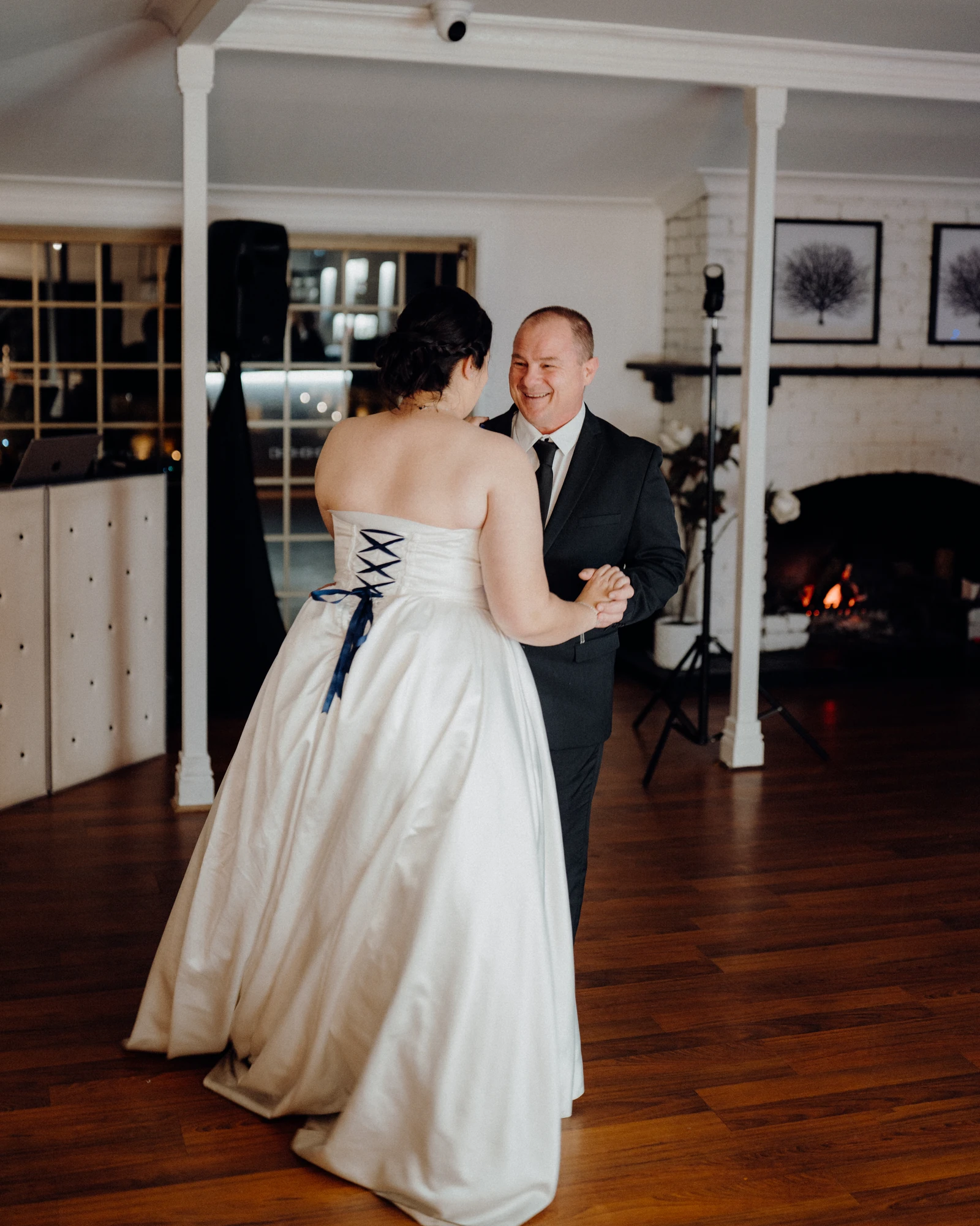 A bride dances with an older man at her reception.
