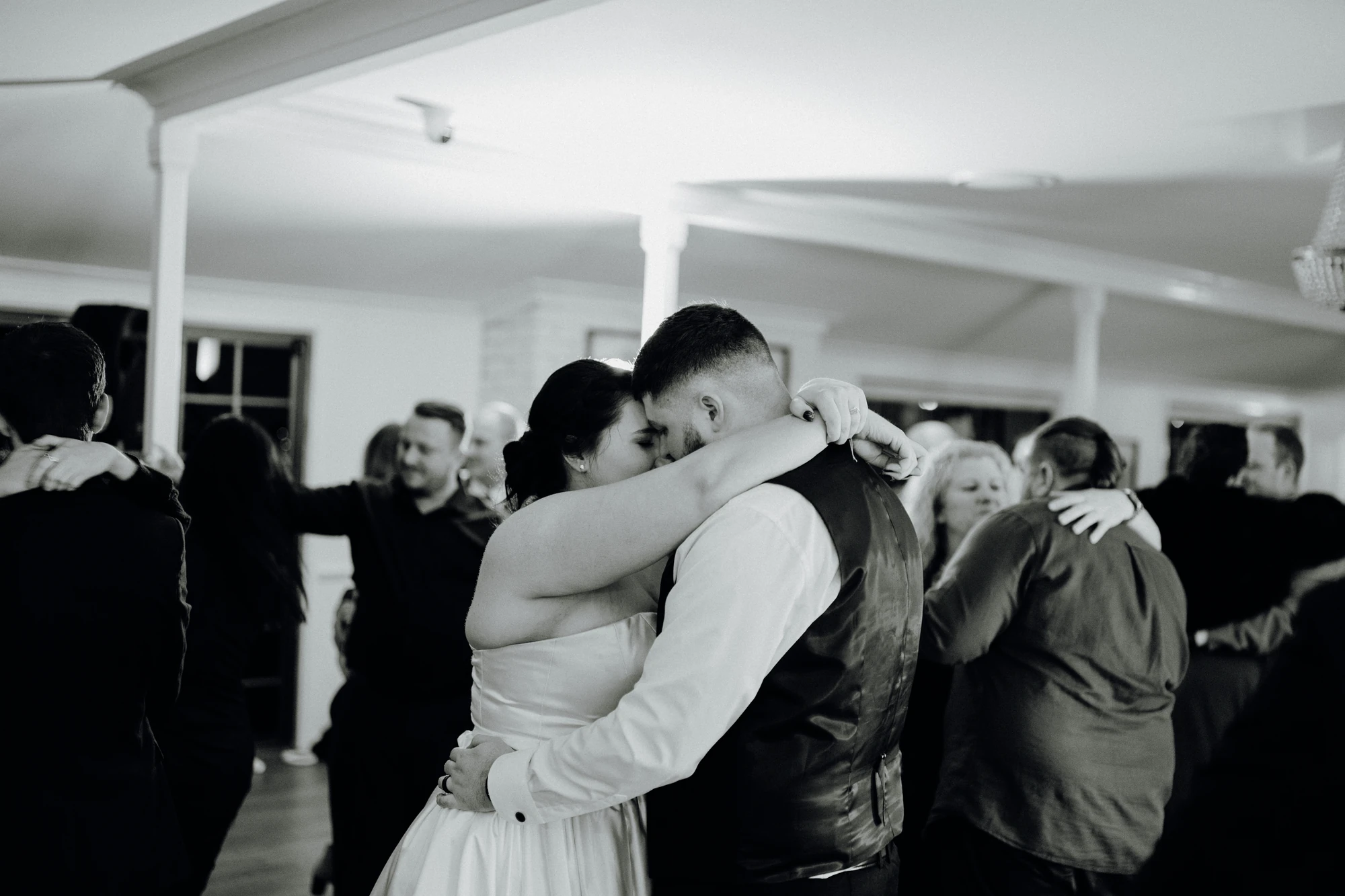 A couple embrace on the dance floor in black and white.