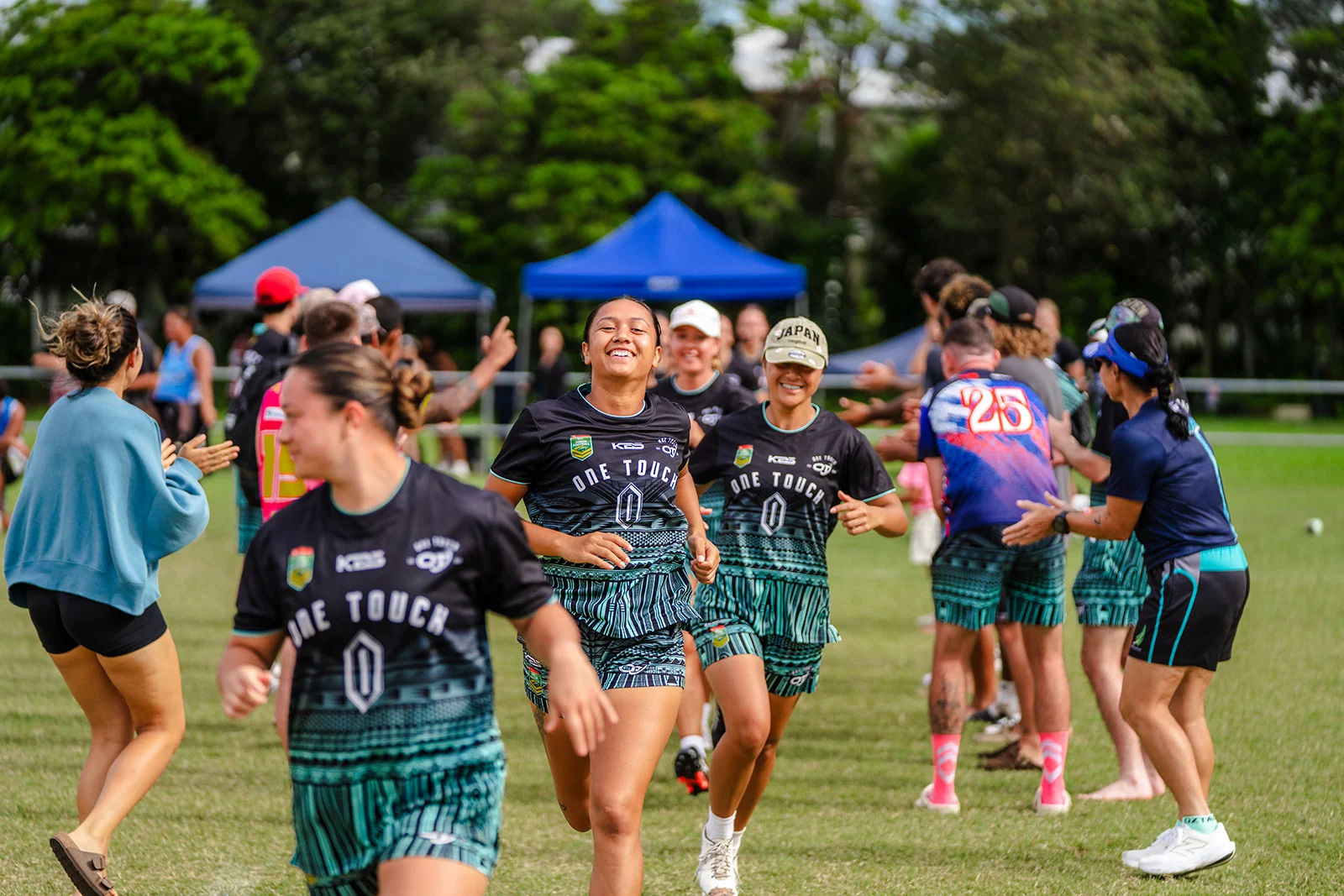 Smiling teammates run through a line of applauding players after their game.