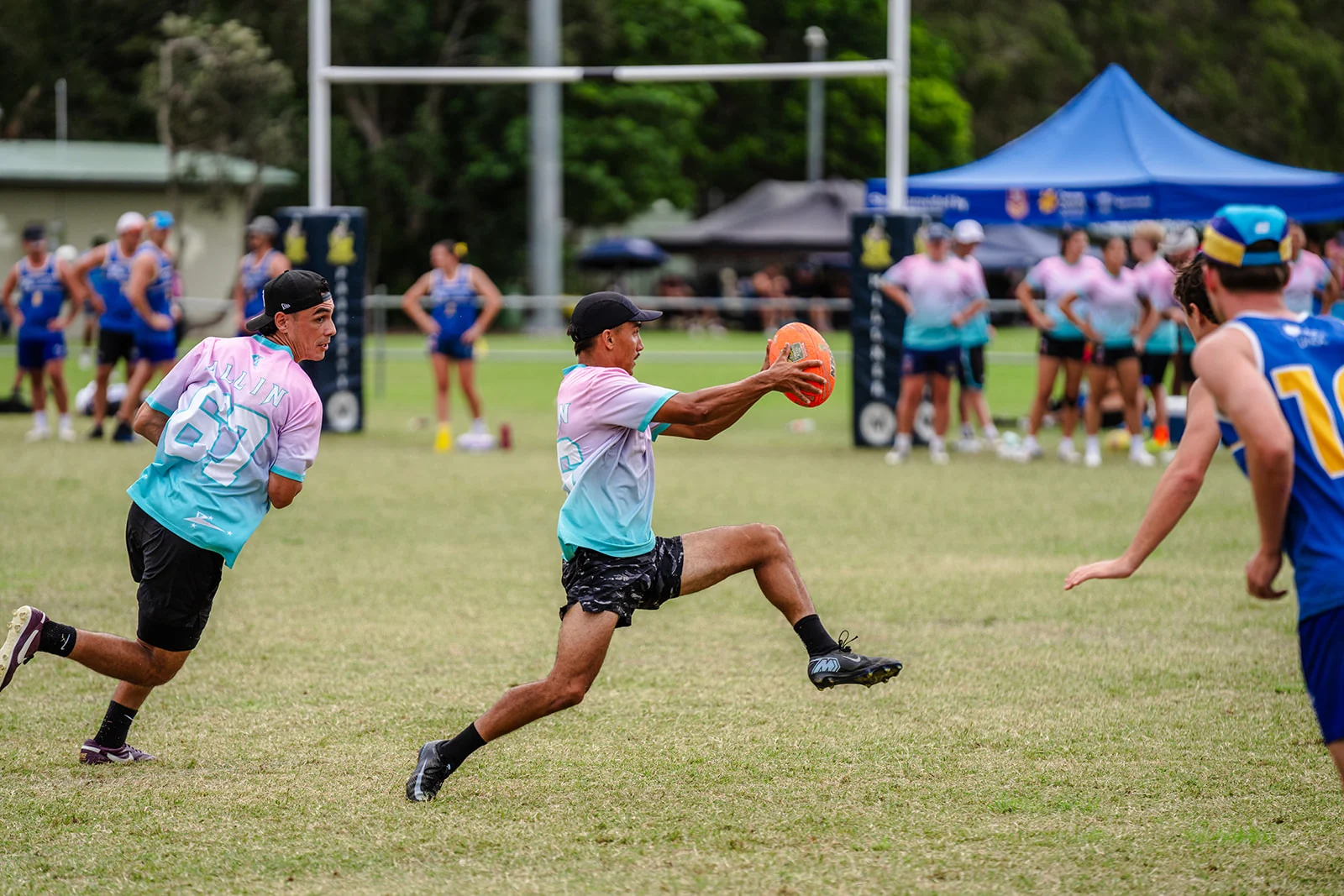 A player leaps forward with an orange ball held in an outstretched hand.