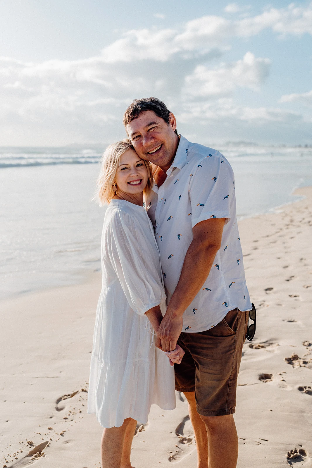 A couple laughs together at the shoreline.