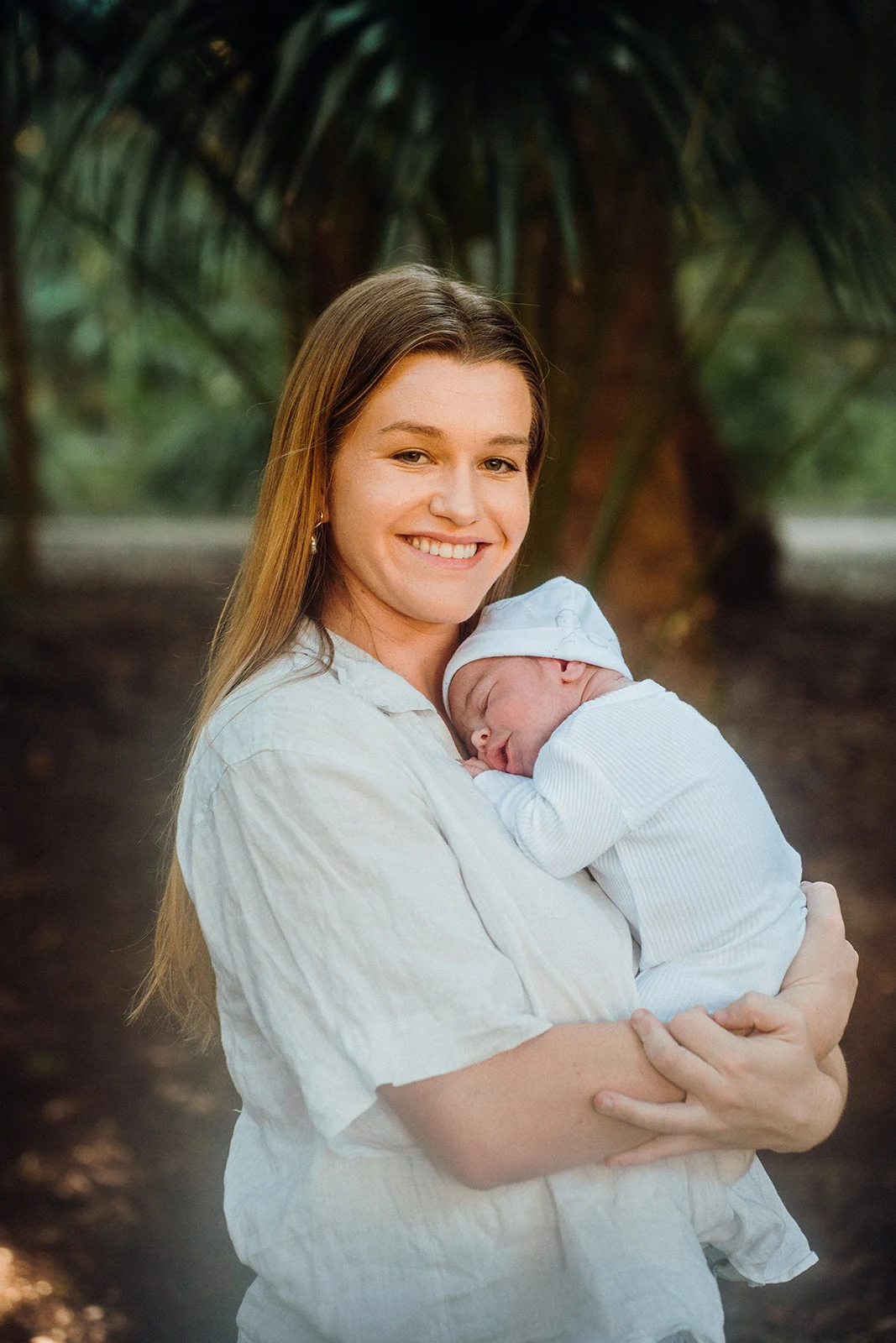 A mother smiles while cradling her newborn.