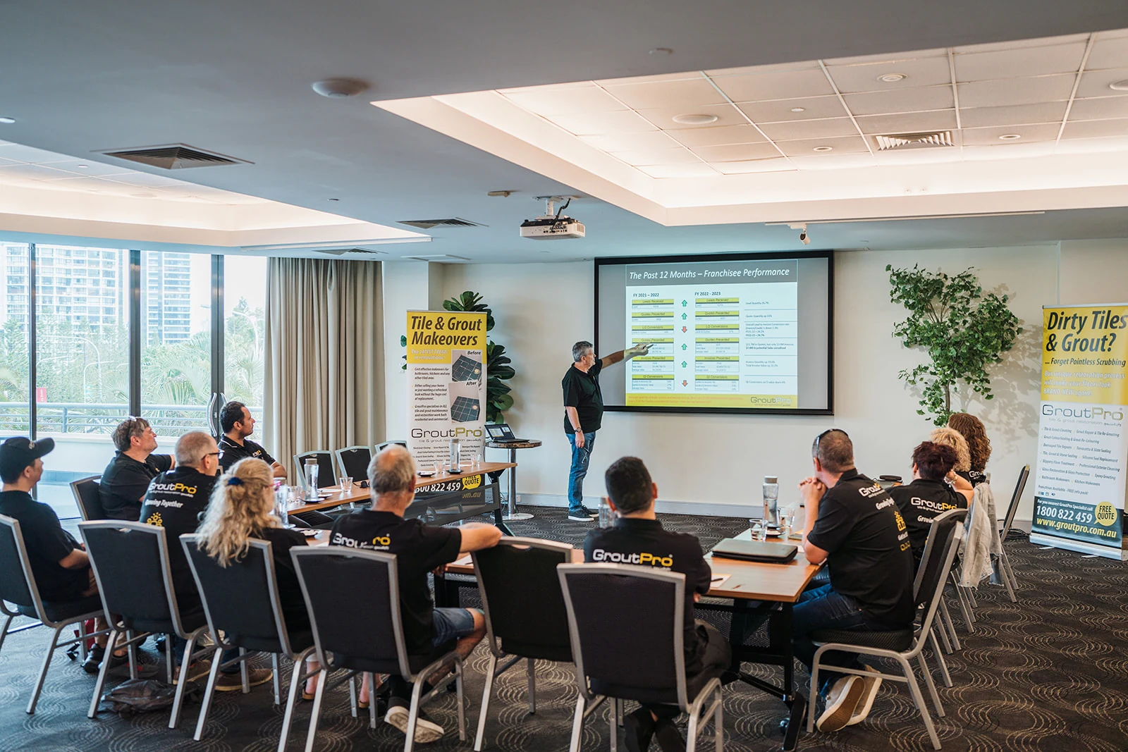 A presenter leads a session in a bright conference room.