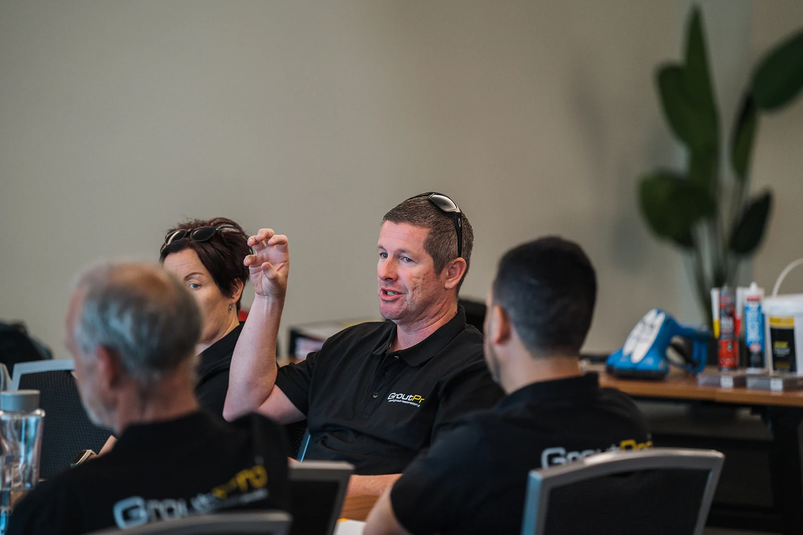 An attendee raises a hand while making a point in a group discussion.