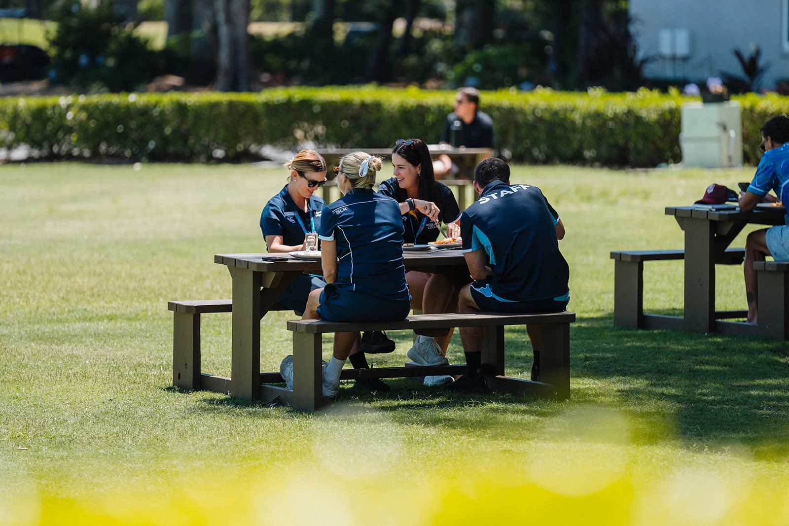 Attendees gather at a picnic table during an outdoor conference break.