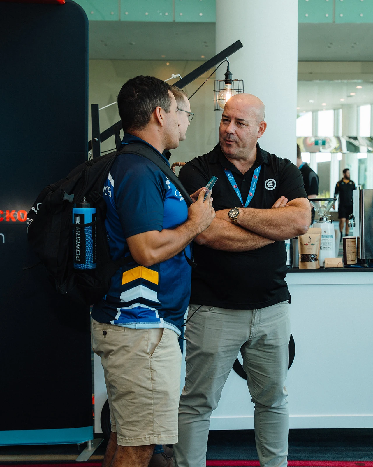 Two attendees talk in the conference foyer.